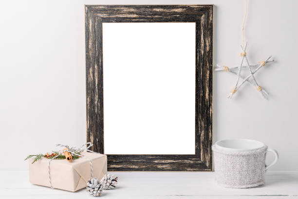 istock Empty white frame mock up. Black wooden frame mockup with christmas decorations on a white background 1066271278