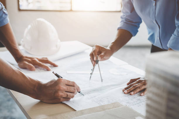 istock Hands of architect or engineer working on blueprint meeting for project working with partner on model building and engineering tools in working site, Construction concept 1066272898