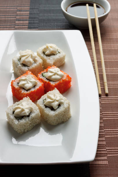 istock Exotically japanese seafood, roll are lying on a white plate. 1066273998
