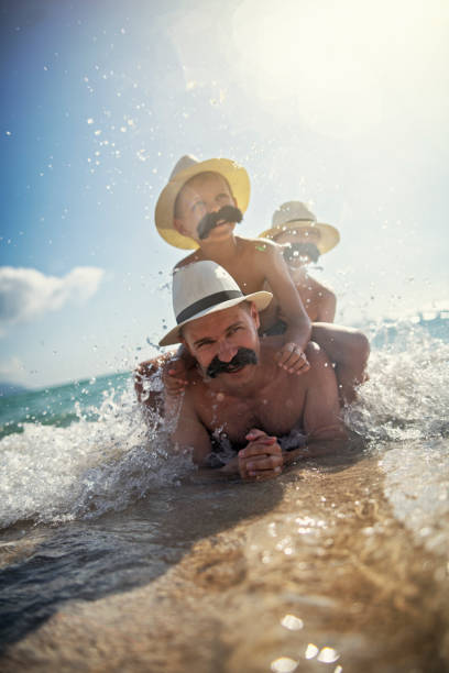 istock Funny father ands sons with moustaches playing at sea 1066274016