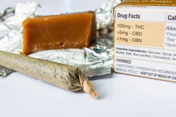 Marijuana joint with THC infused Carmel candy Marijuana joint with THC infused Caramel candy on white background. Drug facts on box up close. bud candy stock pictures, royalty-free photos & images