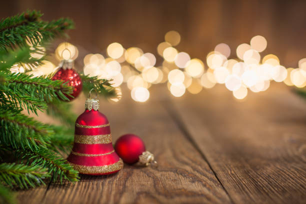istock Fir twig and red bell bauble on rustic wood and sparkles light backgorund 1066284810