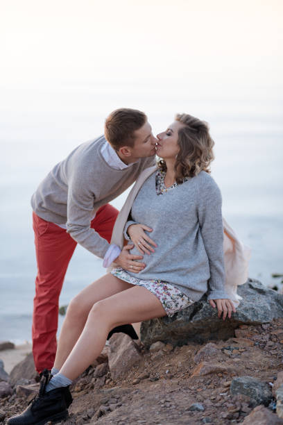 romantic couple kiss each other while waiting for a baby - couple human pregnancy sunset walking imagens e fotografias de stock