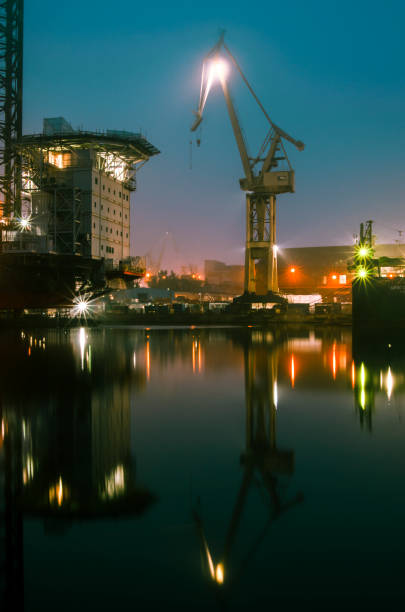 istock Port crane, reflection in water. 1066288714