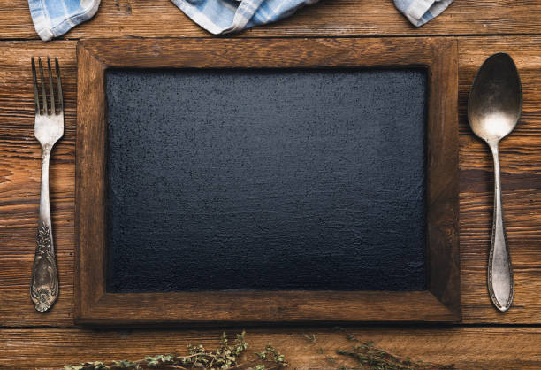 istock Blackboard with fork and knife on wooden background 1066289154