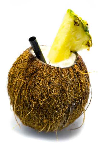 Pineapple and pieces of Pineapple fruit salad inside halved Coconut. Isolated on white background. Selective focus.