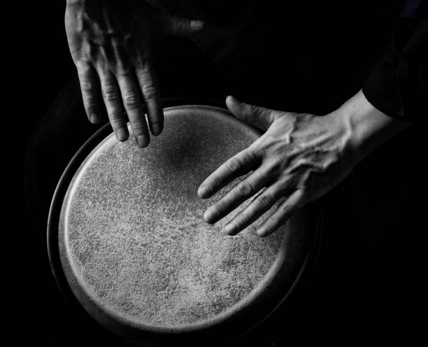 Close up of  a bongo player hand . low key picture with high contrast .Black and white picture.