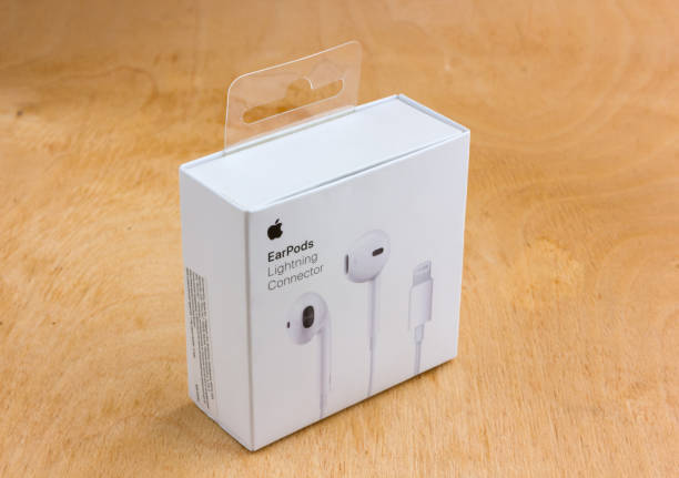 apple earpods mit lightning-anschluss im feld. - adapter apple stock-fotos und bilder