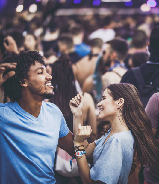 Happy couple having fun while dancing on a music festival.