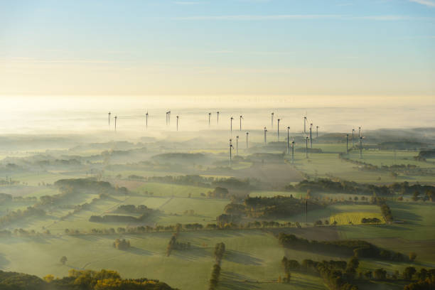 вид с воздуха на пейзаж в тумане с ветряными турбинами - fog wind power energy fuel and power generation стоковые фото и изображения