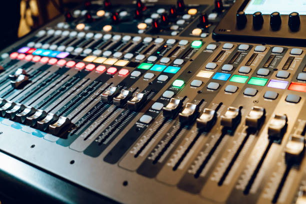 istock Professional audio mixing console with faders and adjusting knobs,TV equipment. The DJ is adjusting the volume of the sound. 1066309728