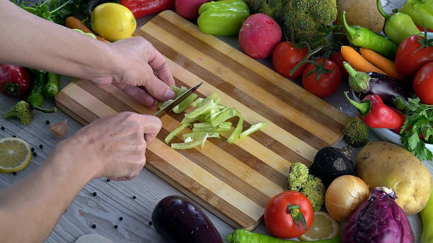 istock Man is cutting vegetables in the kitchen, slicing tomato in slow motion 1066309886