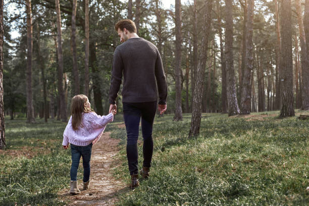 istock Father and daughter walking together in the forest. Rear view 1066310128