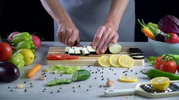 istock Man is cutting vegetables in the kitchen, slicing tomato in slow motion 1066319814