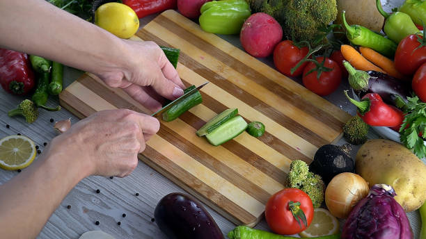 istock Man is cutting vegetables in the kitchen, slicing tomato in slow motion 1066320048