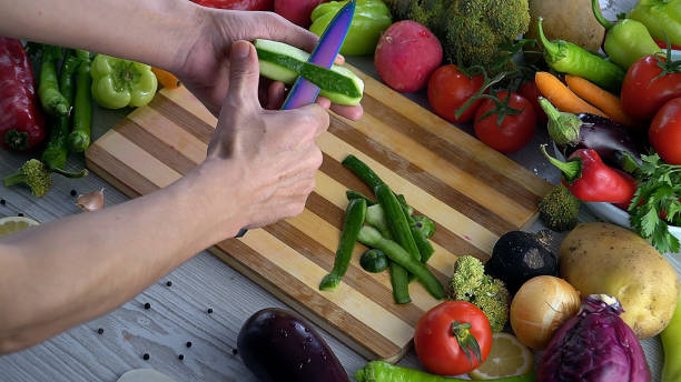 istock Man is cutting vegetables in the kitchen, slicing tomato in slow motion 1066320480