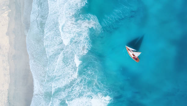 Photo of Yacht on the water surface from top view. Turquoise water background from top view. Summer seascape from air. Travel concept and idea