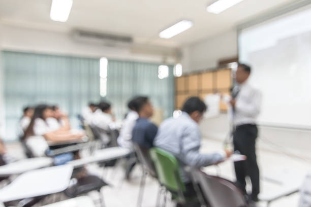 Blurred abstract background university students sitting in seminar lecture room with teacher in front of class
