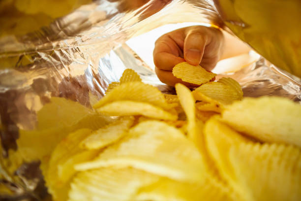 istock Hand hold potato chips inside snack foil bag 1066357964