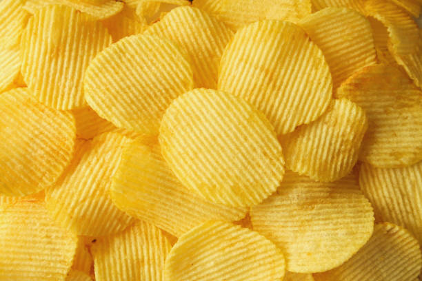 istock crispy potato chips snack texture background closeup top view 1066357968