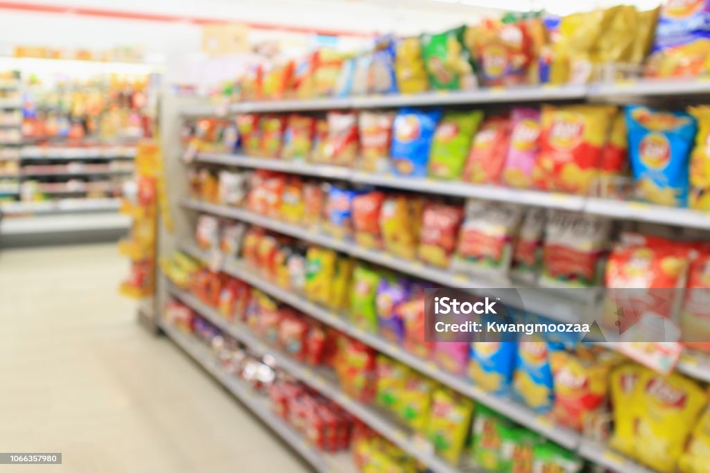Supermarket convenience store shelves with Potato chips snack blur abstract background Snack Stock Photo