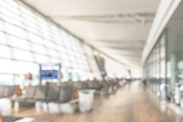 airport blur background for air transportation travel concept with blurry bench seats for traveller or tourist on corridor in waiting area of airport departure flight or bus terminal building interior - vehicle interior indoors window chair imagens e fotografias de stock