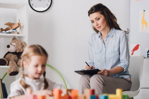 istock little child playing with blocks while psychologist sitting blurred on background 1066366794