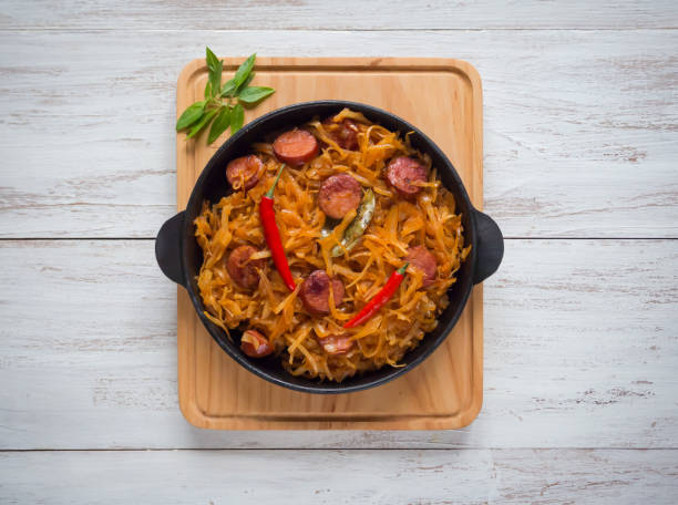istock Stewed cabbage with sausages on a portion pan. Top view. 1066376262