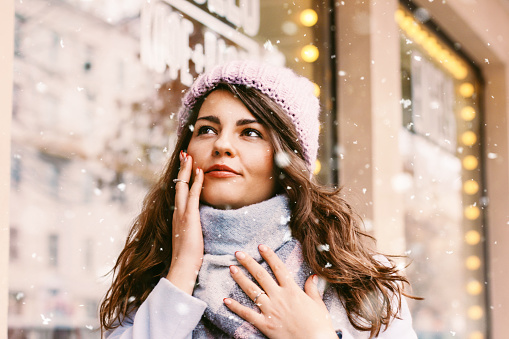 Beautiful young woman drinking hot cocoa outdoors during holidays