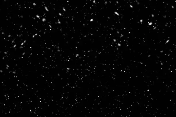 Falling snow on black background. Winter background in pure dark. Heavy snow.