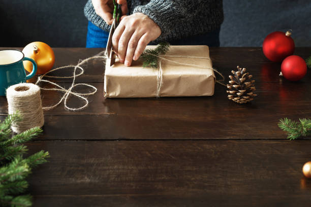 istock Male hands wrapping gift box wooden table Rustic Christmas presents background 1066432722