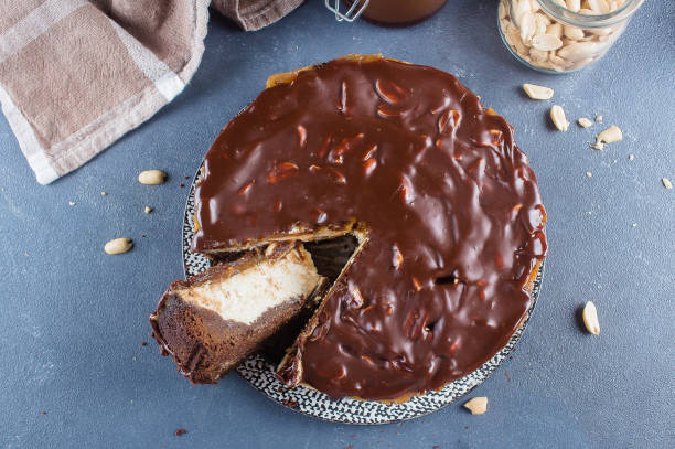 istock ?heesecake Snickers with chocolate, caramel, peanut paste, Nougat and Peanut Layered Cake on blue concrete table background. Top view 1066439926