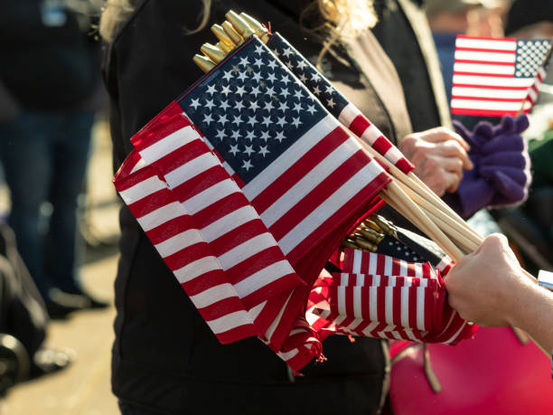 Albany, Oregon, USA - November 10, 2018: This part of the parade in Downtime Albany shows  small USA flags in a hand with spectators in background. This large Veteran's Day Parade is held annually in Albany, Oregon. This year it celebrated the send off of the U.S. Capitol Christmas Tree going to Washington, DC West Lawn of the U.S. Capitol.