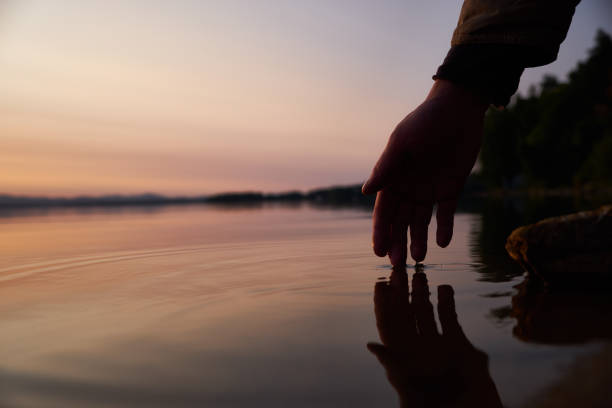 istock Human hand touching the fresh water from lake 1066445968