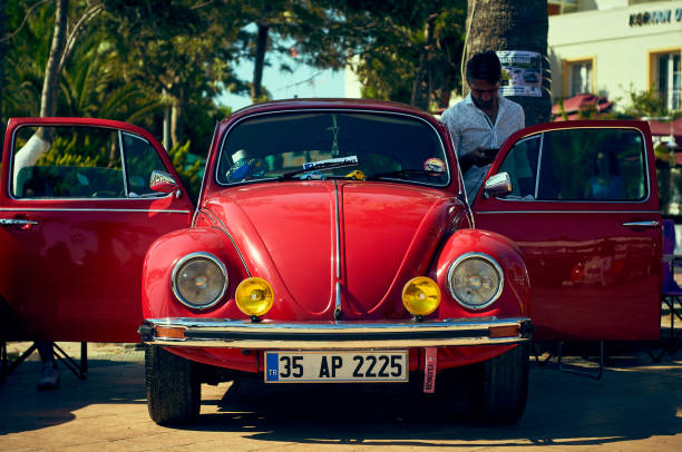 The city of Turgutreis , Bodrum, Turkey - August 12, 2018.  Open, free exhibition of cars on the embankment of the resort town of Turgutsreis. Turkey. Retro car Volkswagen beetle red.