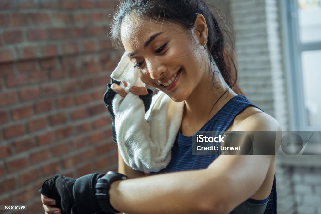 Asian girl exercising in gym she tired and She has sweat on her face. Sweat Stock Photo