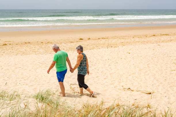 istock Senior Couple Walking Together on the Beach 1066463082