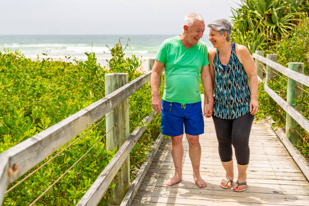 istock Senior Couple Walking on a Boardwalk at the Beach 1066463090