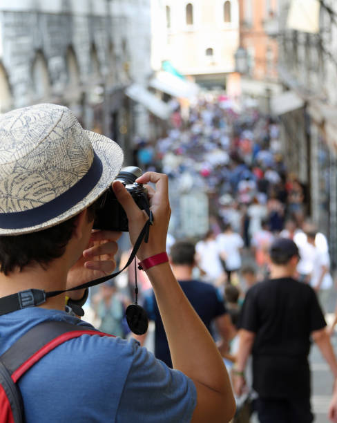 istock guy photographs people walking along the road 1066464682