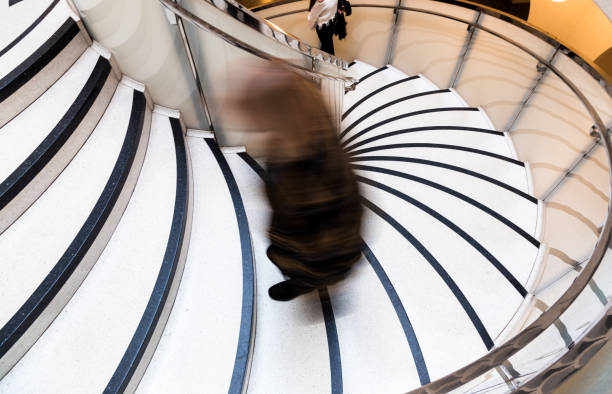 istock Motion Blur of People on Abstract Spiral Staircase 1066470672