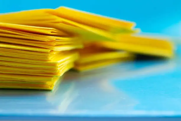 Photo of stack of yellow paper on blue table