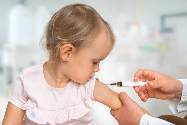 врач-педиатр вводит вакцину в плечо ребенка - injecting flu virus cold and flu doctors office стоковые фото и изображения