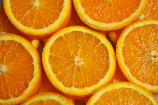 istock tropical citrus fruit - bright orange orange sliced into slices 1066472380