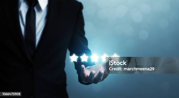 Businessman Hand Holding Five Star Symbol To Increase Rating Of Company Concept Stock Photo - Download Image Now