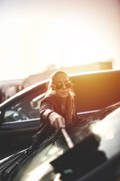 istock Young woman washing car windows 1066478516