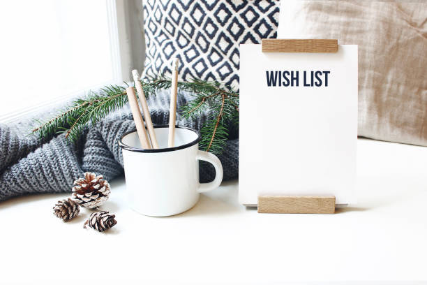 winter desktop still life scene. wish list card, board and wooden pencils in mug standing near window on white table background. christmas concept. pine cones and fir branch on wool plaid. - fir branch imagens e fotografias de stock