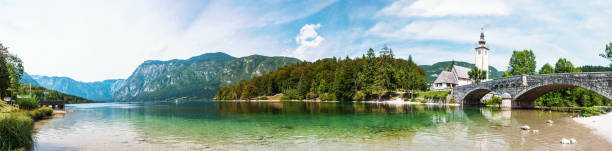 reflection of the holy spirit church, lake bohinj slovenia. panorama - lake bohinj imagens e fotografias de stock