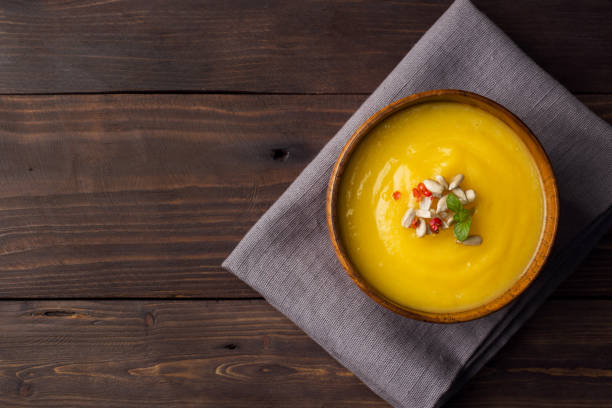 istock Pumpkin soup mashed with spices in wooden bowls on dark boards. 1066488224