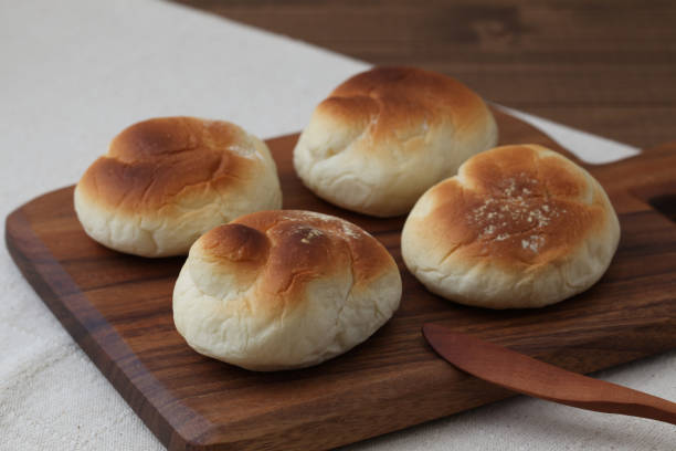 istock baked white bread on wood cutting board isolated on table 1066489486