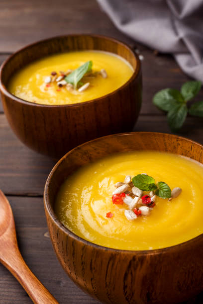 istock Pumpkin soup mashed with spices in wooden bowls on dark boards. 1066489560